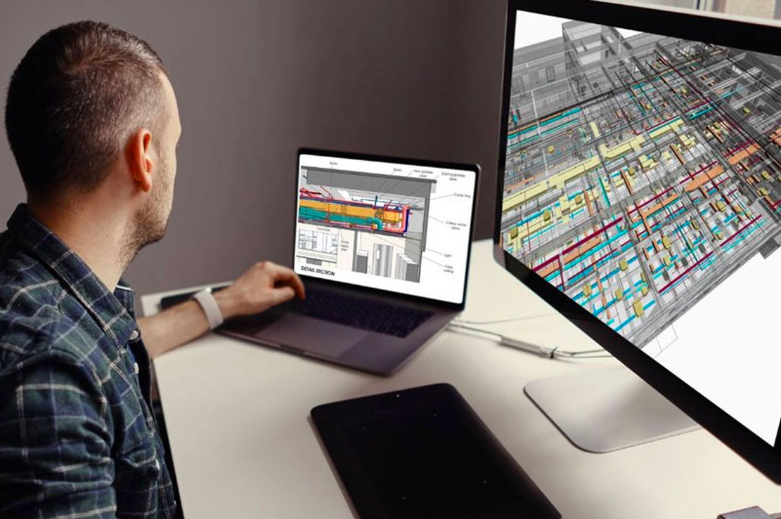 Interior designer reviewing space plans during site feasibility study with multiple screens Interior designer reviewing space plans during site feasibility study with multiple screens
