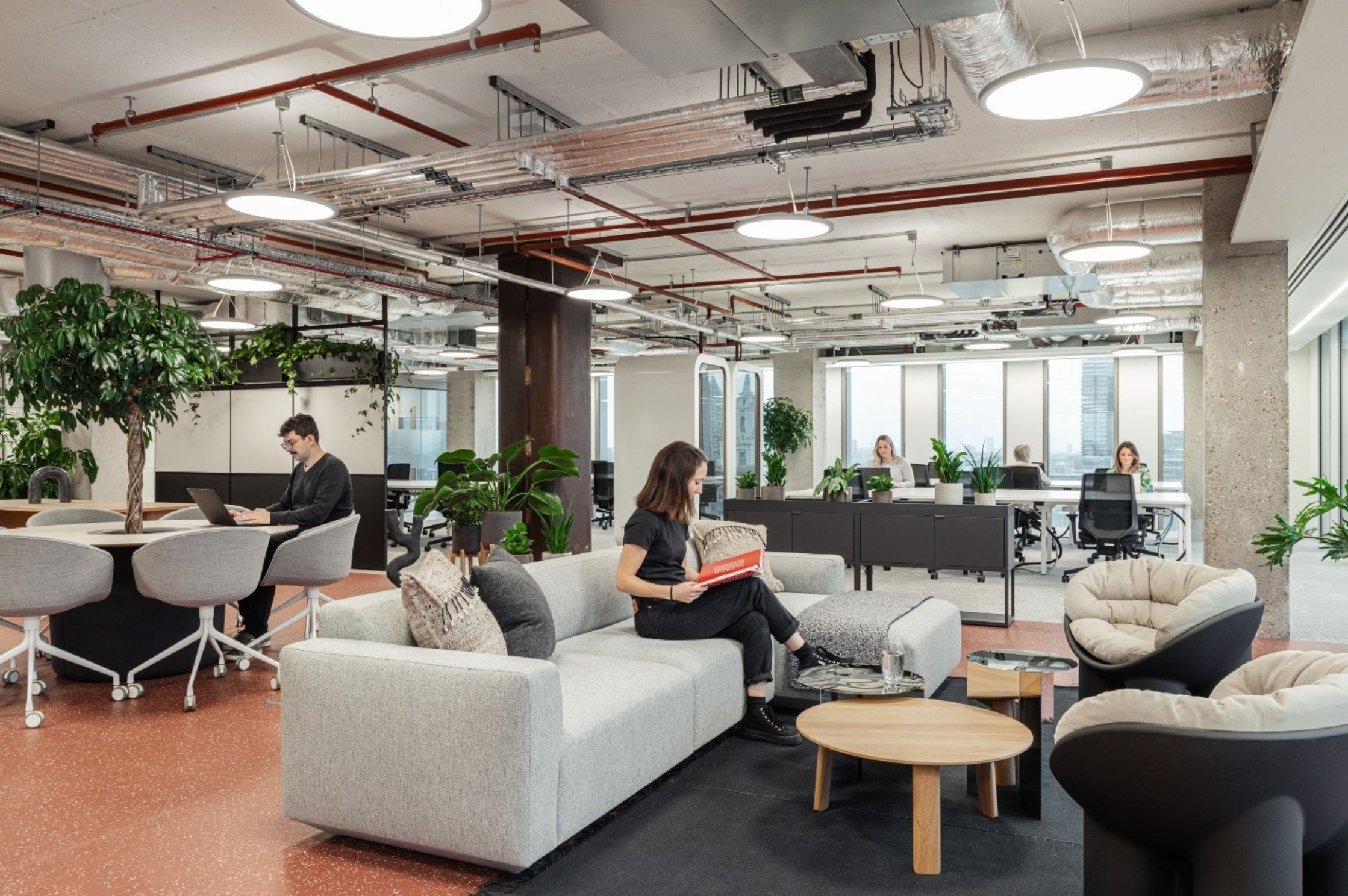 Biophilic design at its finest: A collaborative workspace where comfort meets nature, enhancing well-being and creativity among professionals.